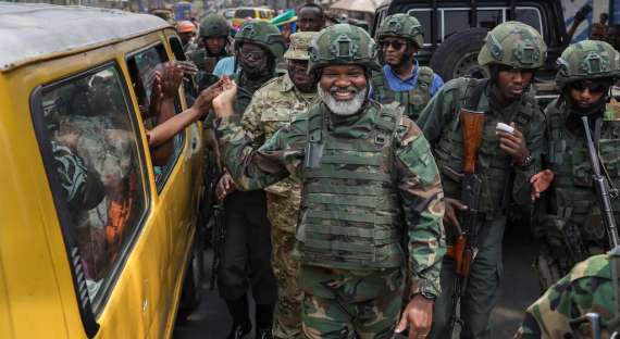 Leader of Alliance Fleuve Congo (AFC), Corneille Nangaa (C), a political-military movement of rebel groups including the M23 group, shakes hands with passengers in a public service taxi as he is received with jubilation by residents during a clean up excercise of the city of Goma on February 1, 2025. The Rwandan-backed M23 group was pushing south in mineral-rich eastern DR Congo as the United Nations warned the escalating conflict had killed at least 700 people in less than a week. The M23 took vital eastern trade hub Goma after intense fighting this week and has vowed to march all the way to the Democratic Republic of Congo capital. (Photo by Tony KARUMBA / AFP)